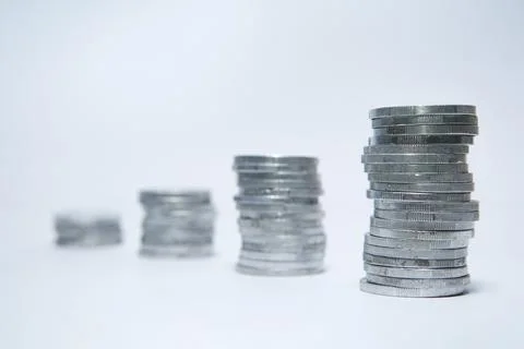 Pile of silver coins stack and growing money graph on rows of 5, 10, 15, 20.. Stock Photos