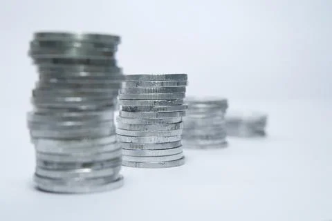 Pile of silver coins stack and growing money graph on rows of 5, 10, 15, 20.. Stock Photos