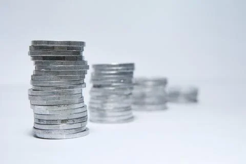 Pile of silver coins stack and growing money graph on rows of 5, 10, 15, 20.. Stock Photos