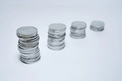 Pile of silver coins stack and growing money graph on rows of 5, 10, 15, 20.. Stock Photos