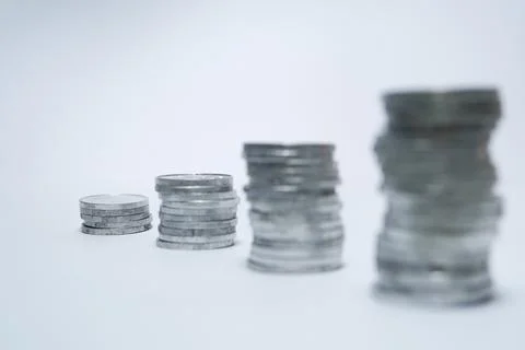 Pile of silver coins stack and growing money graph on rows of 5, 10, 15, 20.. Stock Photos