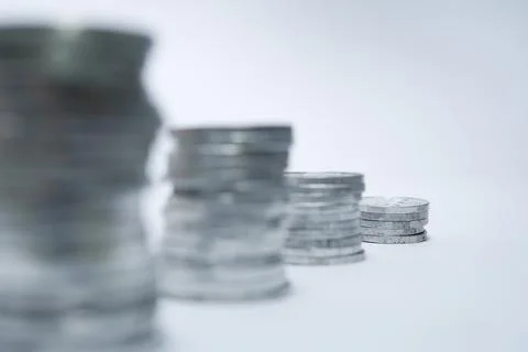 Pile of silver coins stack and growing money graph on rows of 5, 10, 15, 20.. Stock Photos