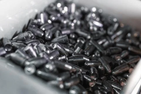Pile of small caliber hunter bullets in plastic container Stock Photos