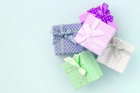 Pile of a small colored gift boxes with ribbons lies on a violet background Photos