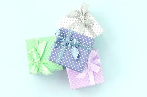 Pile of a small colored gift boxes with ribbons lies on a violet background Stock Photos