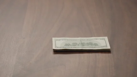 Pile stack of hundred dollar bills on walnut table slide shot Stock Footage 255901181
