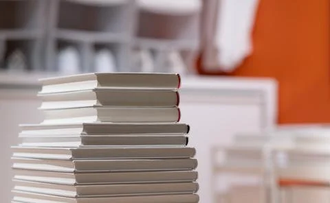 Pile stack of white books on table in modern interior. Study or education. Stock Photos