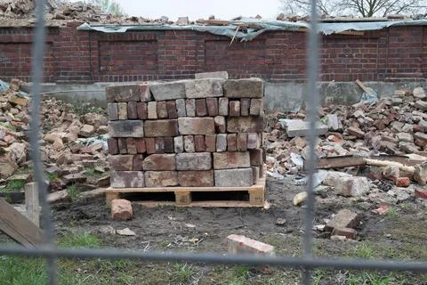 Pile of stacked bricks against the background of a demolished building 写真素材