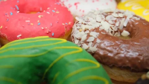 A pile of stacked multi-colored donuts with different flavors. Tracking shot. Stock Footage 262981321