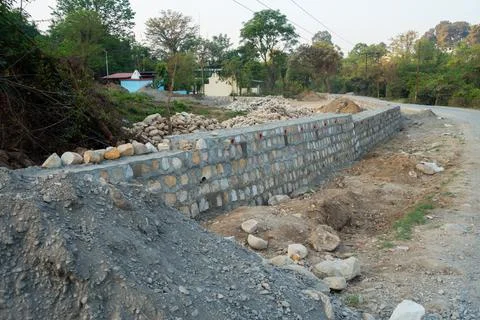 A pile of stone alongside road for constructing a stone retaining wall to pre 스톡 사진