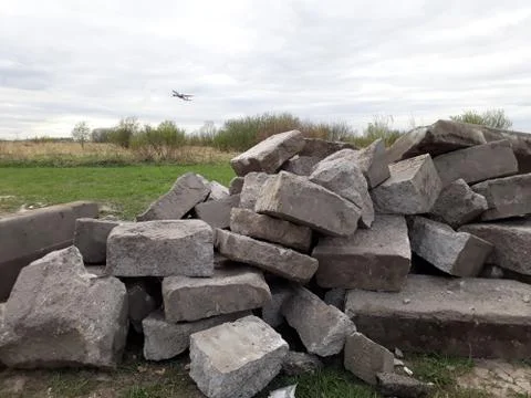 Pile of stone blocks and a plane taking off Stock Photos
