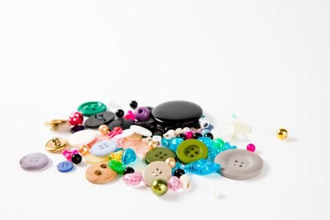 Pile of tailor's knobs of many sizes shapes and colors - on white background. Stock Photos