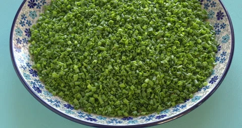 A pile of thinly chopped organic chives on a plate. Vídeo Stock 334564575