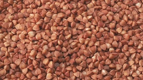 Pile of uncooked brown buckwheat, close shot. Dolly shot of texture of buckwheat Stock Footage 127608689