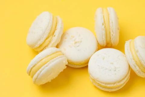 Pile of vanilla macarons on yellow background Fotos Stock