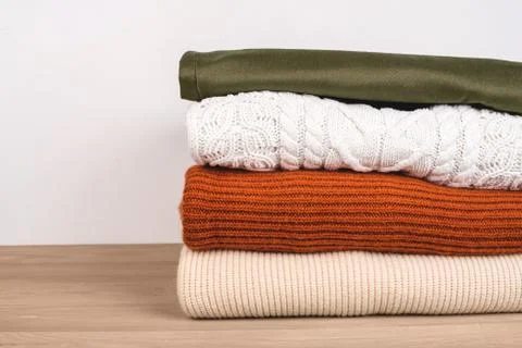 Pile of warm clothes on the table. Stock Photos