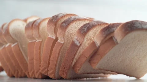 A pile of white bread bouncing on a separate table in slicies. 4K footage Stock Footage 231503901