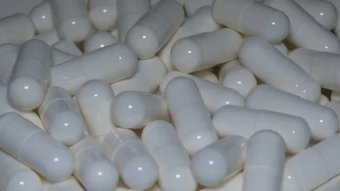 Pile of white capsules rotating Stock Footage 146313144
