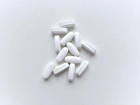A pile of white pills on a white background Stock Photos