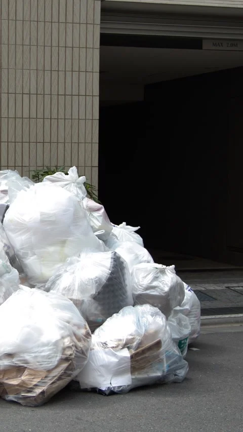 Pile of White Plastic Garbage Bags on Tokyo City Street Stock Footage 343593650
