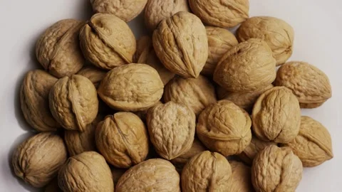 Pile of whole walnuts in shells rotating on white Stock Footage 328143170