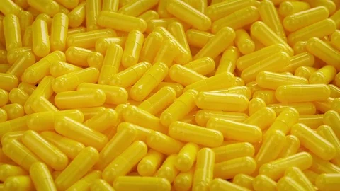 Pile Of Yellow Medical Capsules Rotating Stock Footage