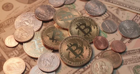 Piled up Bitcoin on top of US Dollar banknotes and coins. Stock Footage 176713217