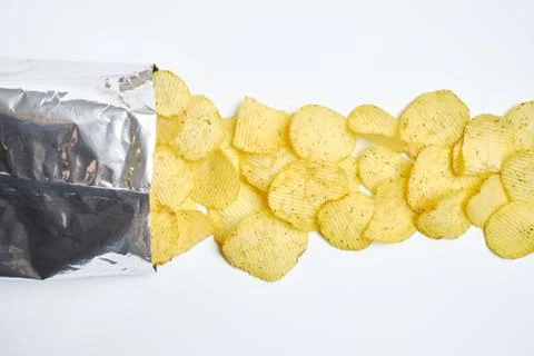 Piled chips in foil packaging in a line on a white background. Stock Photos