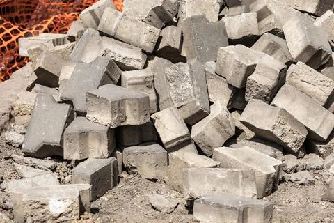 Piled concrete bricks at a construction site, awaiting installation for pavement Foto stock