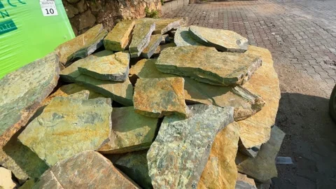 Piled natural stone slabs on pavement used for construction or landscaping .. Stock Footage 328991402