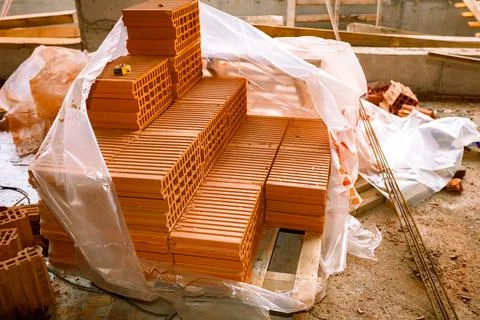 Piled red blocks, packed in opened plastic foil Stock Photos