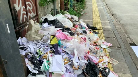 Piled trash dominates sidewalk. Stock Footage 334155037