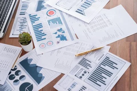 Piles of analyzed financial data dashboard on wooden table. Meticulous Stock Photos