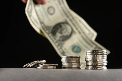 Piles of coins in a stack of different denominations on a black background and a Photos
