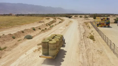 Piles of hay are getting collected by agricultural machines in haystack. Bale of Stock Footage 155625660
