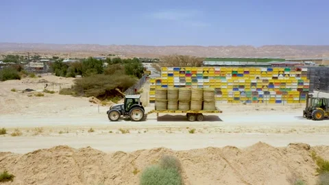Piles of hay are getting collected by agricultural machines in haystack. Bale of Stock Footage 155626103