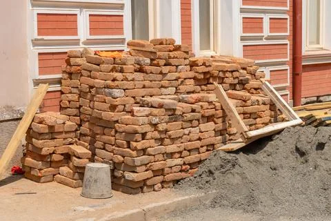 Piles of old red construction bricks scattered on the street Stock Photos