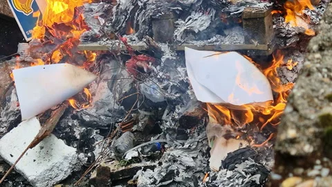 Piles of paper archives and documents burn outdoors in a controlled fire Vídeo Stock 321771561