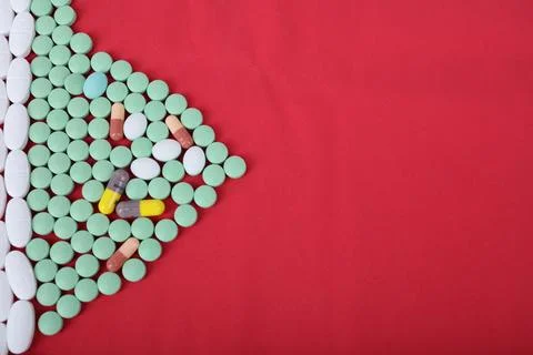 Piles of pills on a red background Stock Photos