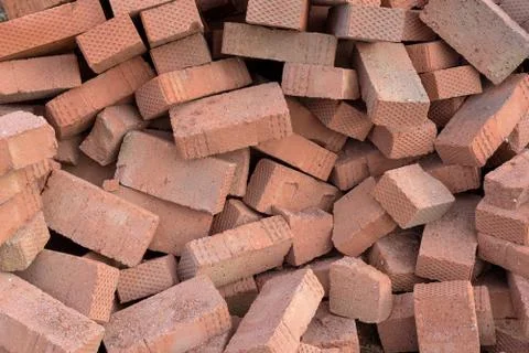 Piles of red construction bricks scattered on the ground. Copyspace area for  Stock Photos