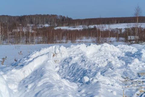 Piles of snow after the work of a tractor to clear rural roads in winter the  Stock Photos