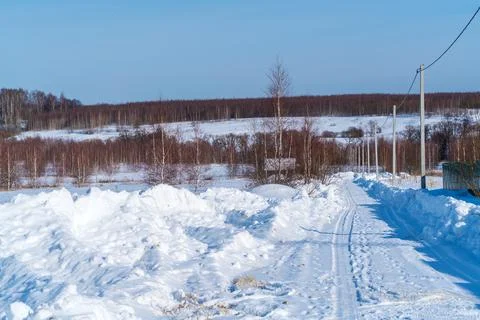 Piles of snow after the work of a tractor to clear rural roads in winter the  Stock Photos