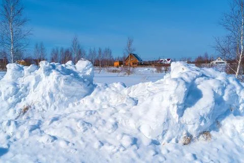 Piles of snow after the work of a tractor to clear rural roads in winter the  Stock Photos