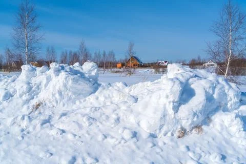 Piles of snow after the work of a tractor to clear rural roads in winter the  Stock Photos
