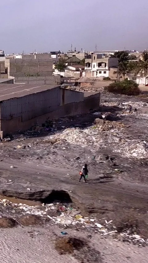 Piles of various waste next to the beach, city buildings in background 動画素材 228800209