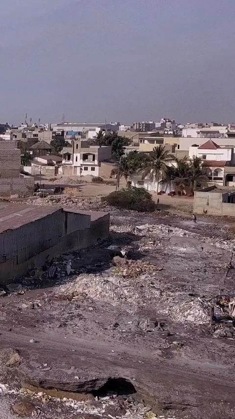 Piles of various waste next to the beach, city buildings in background Video stock 230672827