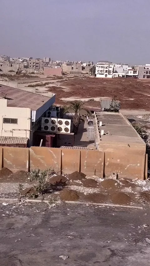 Piles of various waste next to the beach, city buildings in background Video stock 230672866