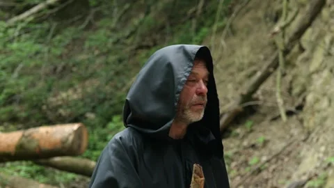 Pilgrim in dark clothing walks through the forest maintaining focus on his spiri Stock Footage 336784376