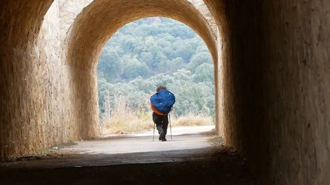 Pilgrim with a large backpack goes through the tunnel 動画素材 113003054