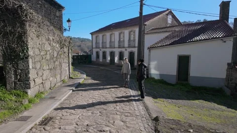 Pilgrim walking across Maceira bridge on Camino de Santiago Видео 325986909